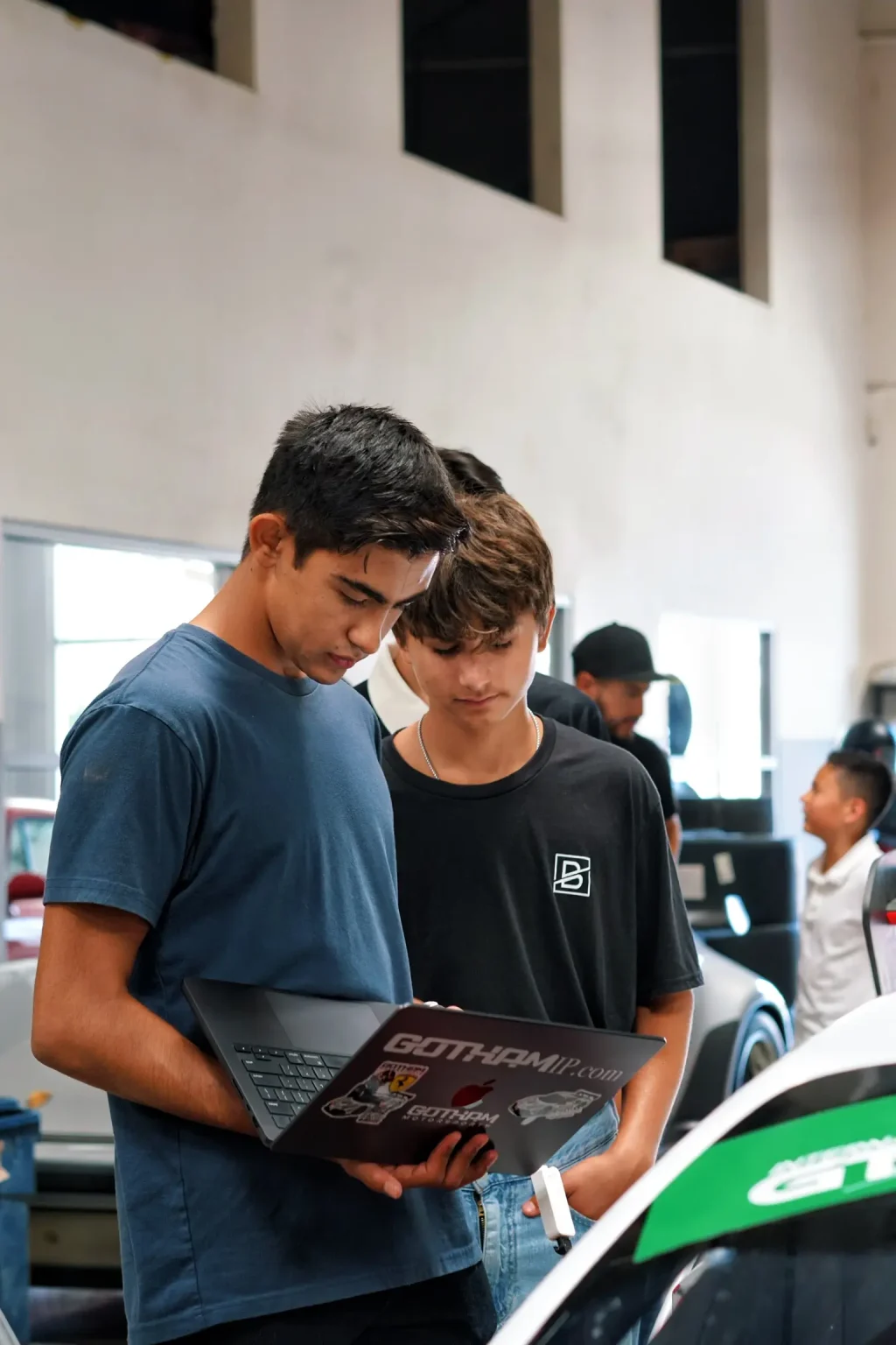 Students looking into a race car cockpit with a Gotham Motorsports team member