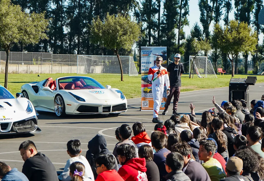 Students at a school assembly with the Gotham Motorsports race cars